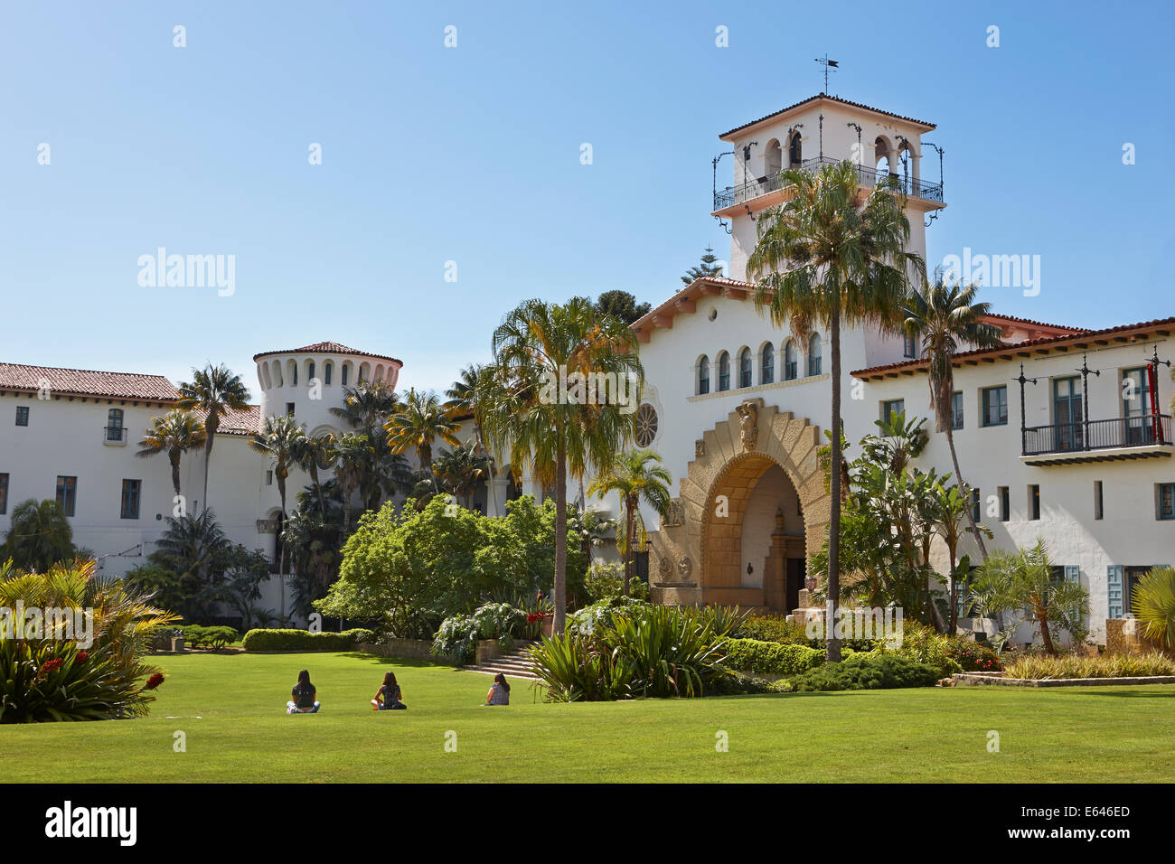 People sit on a neatly manicured green lawn in front of Santa Barbara County Courthouse. Santa Barbara, California, USA. Stock Photo
