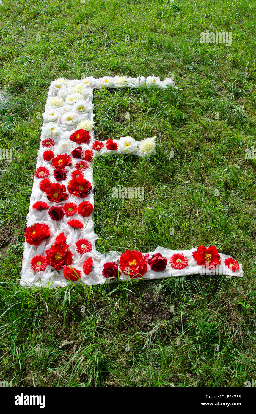 beautiful cloth and flower alphabet letter E on grass in park Stock Photo