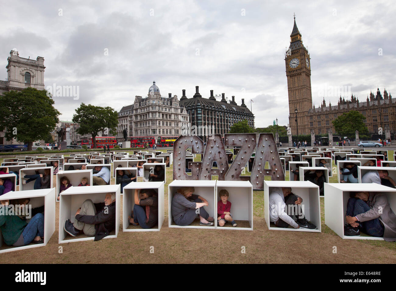 London, UK, Thursday 14th August 2014. In Parliament Square, 150 men, women and children are squashed inside boxes for an Oxfam stunt to illustrate the conditions faced by the people in Gaza who are trapped by the blockade. Credit:  Michael Kemp/Alamy Live News Stock Photo