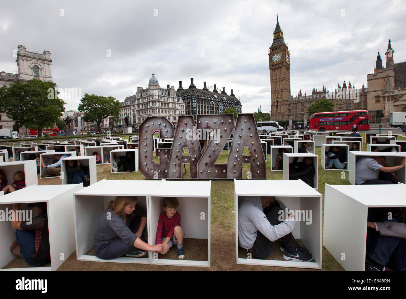 London, UK, Thursday 14th August 2014. In Parliament Square, 150 men, women and children are squashed inside boxes for an Oxfam stunt to illustrate the conditions faced by the people in Gaza who are trapped by the blockade. Credit:  Michael Kemp/Alamy Live News Stock Photo