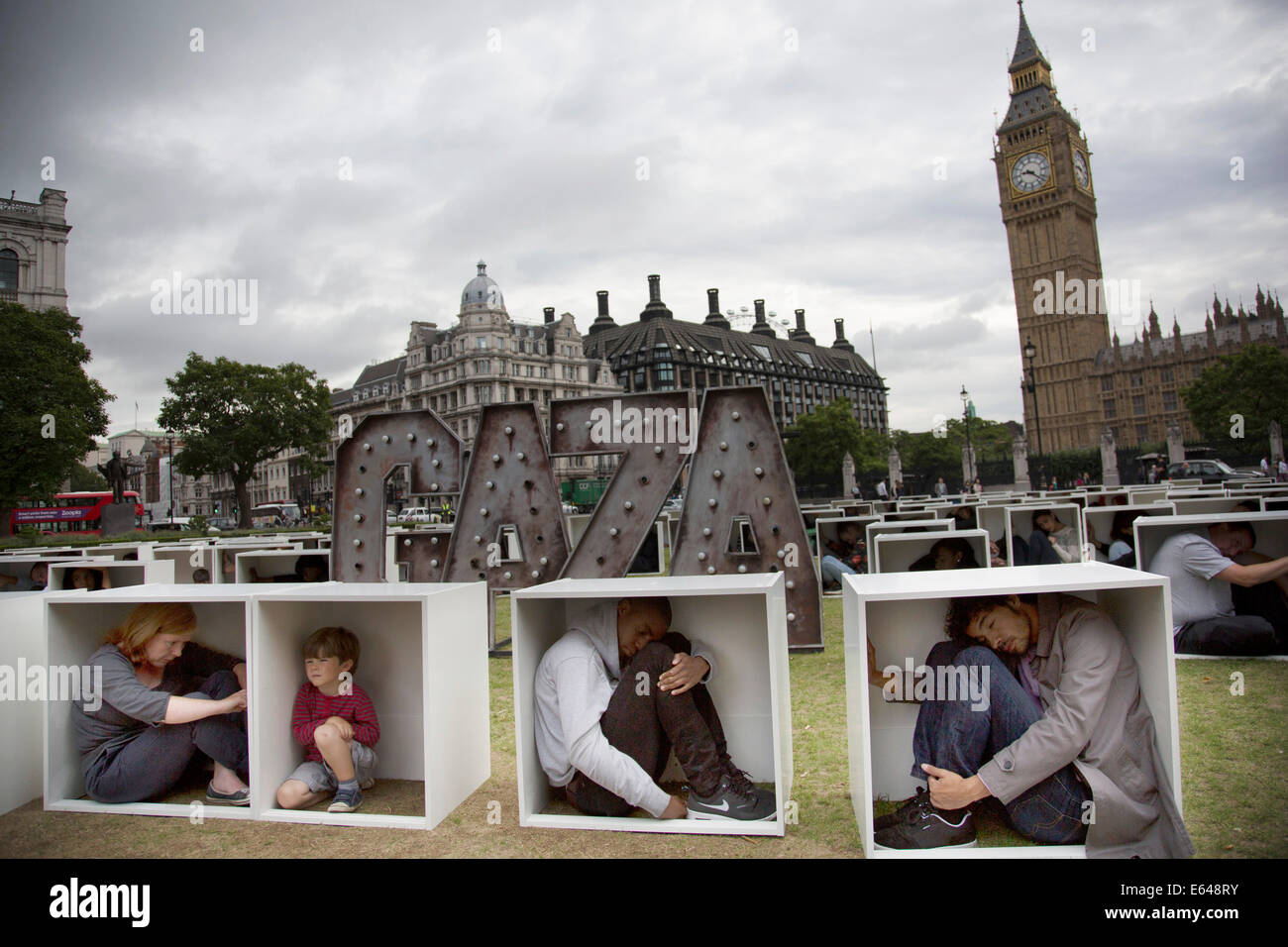 London, UK, Thursday 14th August 2014. In Parliament Square, 150 men, women and children are squashed inside boxes for an Oxfam stunt to illustrate the conditions faced by the people in Gaza who are trapped by the blockade. Credit:  Michael Kemp/Alamy Live News Stock Photo