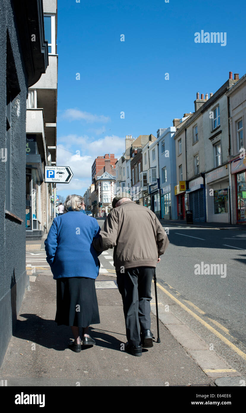 Two senior citizens walking along the High Street Stock Photo