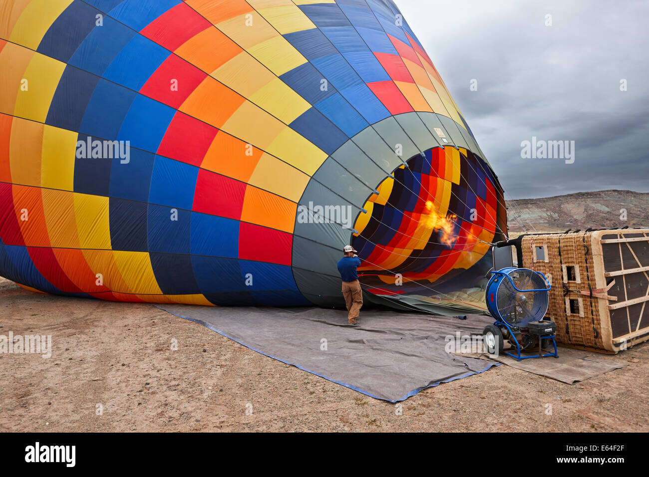 Man inflates hot air balloon for a flight. Moab, Utah, USA. Stock Photo