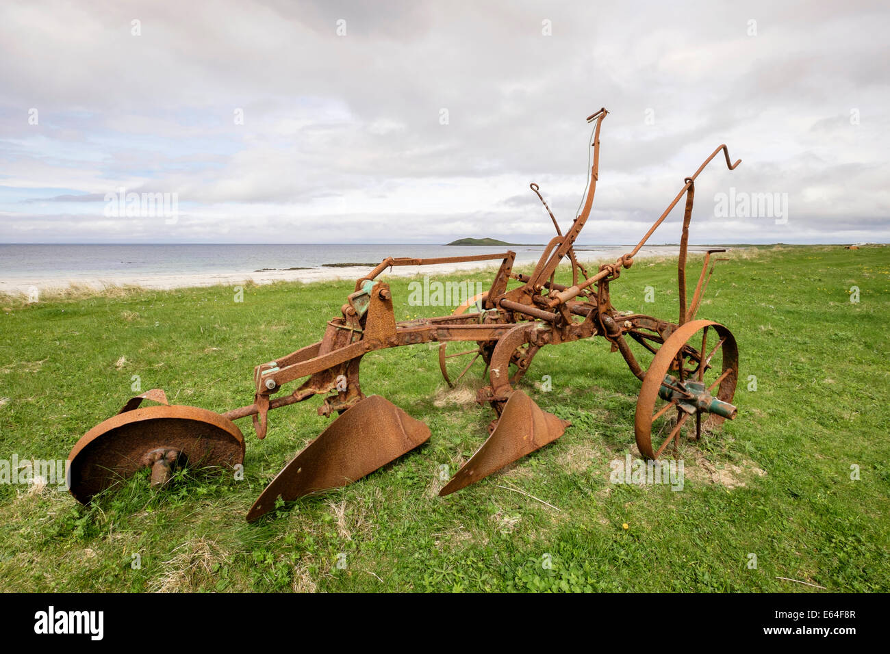 Vintage rusty handplough standing idle abandoned in farm field on west coast of South Uist Outer Hebrides Western Isles Scotland UK Britain Stock Photo
