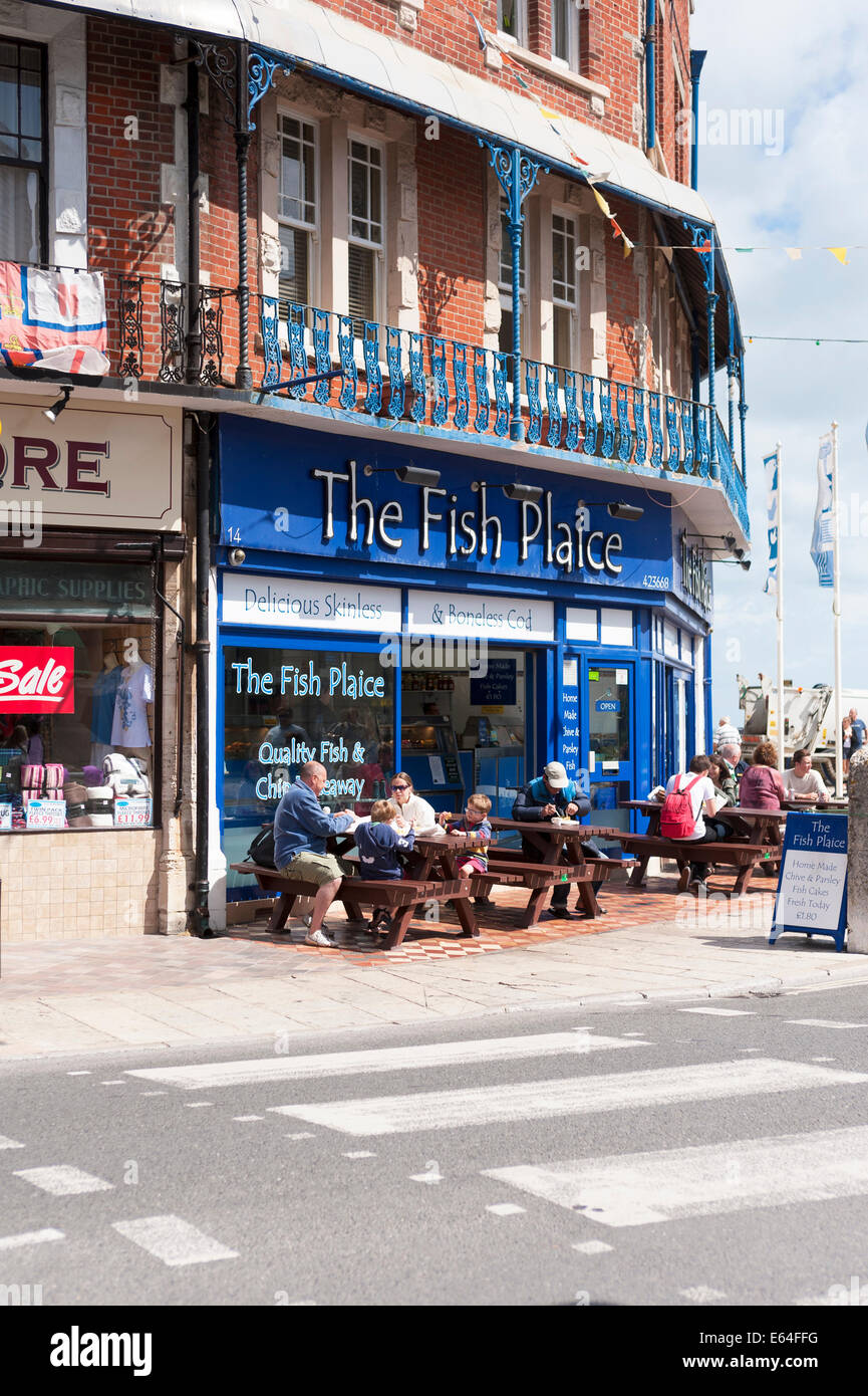 families eating fish and chip lunches alfresco outdoors at the fish plaice in the seaside town of swanage dorset UK Stock Photo
