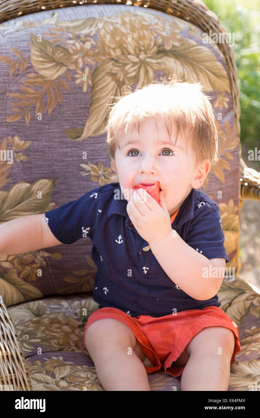 Toddler Looking at Camera Eating Watermelon, USA Stock Photo