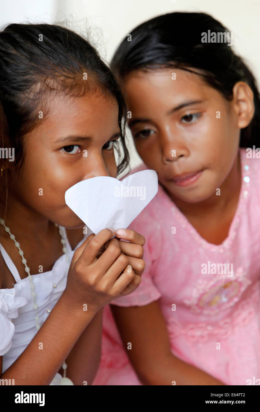 Young girls holding a heart of paper. Dili, East Timor, Timor Leste