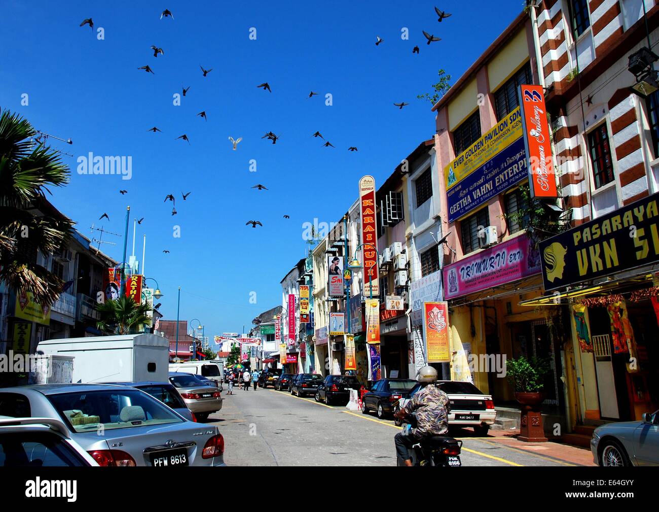 GEORGETOWN, MALAYSIA:  A flock of pigeons flies over Lebuh Pasar Road in Little India * Stock Photo