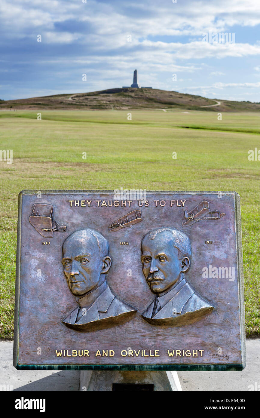 Plaque featuring Wilbur and Orville Wright with Memorial Monument behind, Wright Brothers National Memorial, North Carolina, USA Stock Photo