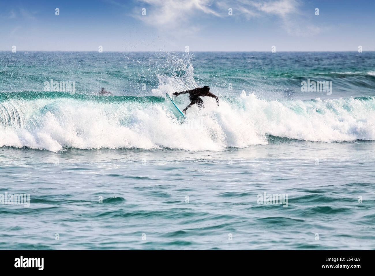 Silhouette of a surfer on waves on famous beach in Sri Lanka. Stock Photo