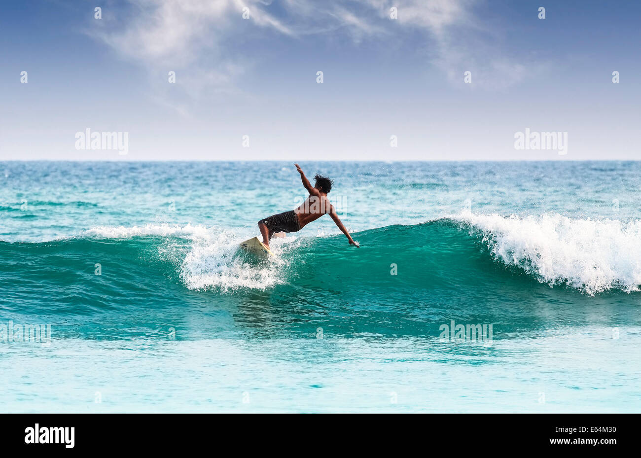Silhouette of a surfer on waves on famous beach in Sri Lanka. Stock Photo
