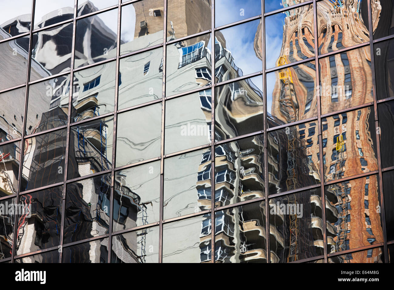 Distorted reflections of high-rise buildings in a glass wall of another highrise on Manhattan. New York, USA. Stock Photo