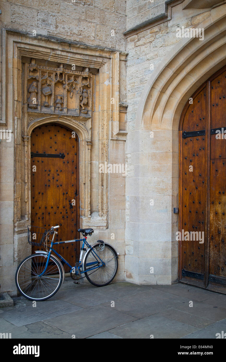 Bicycle parked in front of old wooden doors, Oxford University, Oxfordshire, England Stock Photo