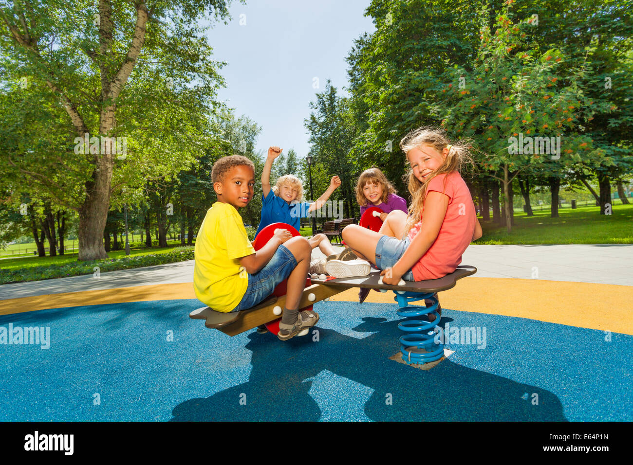 Children sitting on playground carousel together Stock Photo