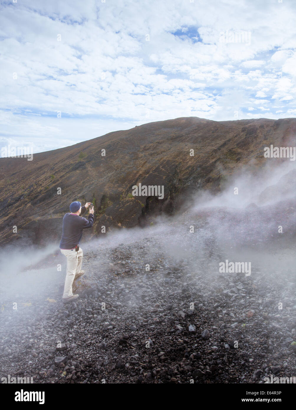 A man photographs the steaming cone of the Paricutin volcano in Michoacan, Mexico. Stock Photo