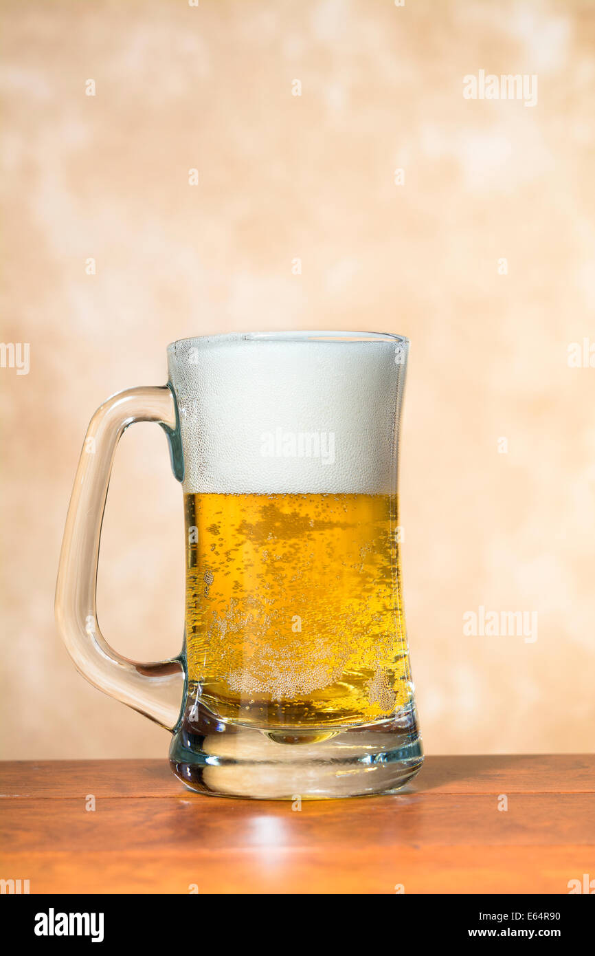 A beer mug freshly filled with cold, crisp beer with a nice foam head