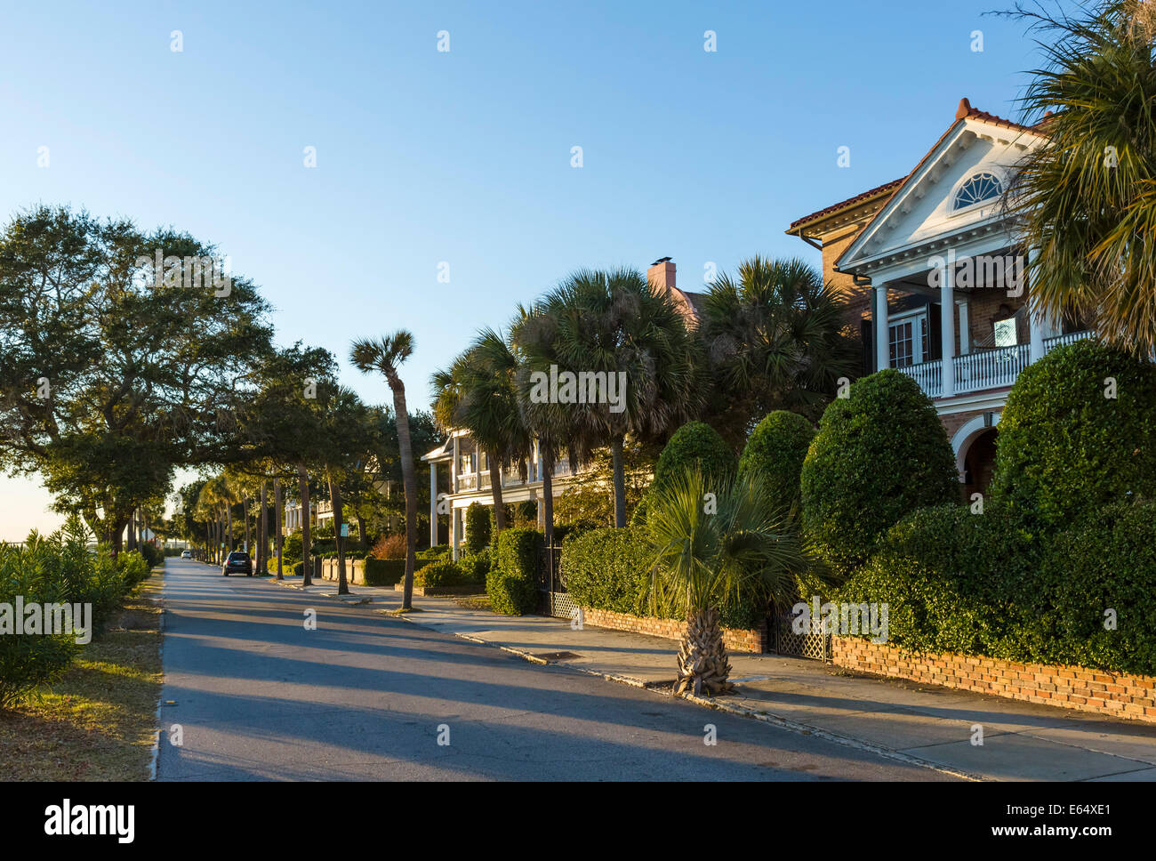 Historic houses along the waterfront on Murray Boulevard, lit by the setting sun, Charleston, South Carolina, USA Stock Photo