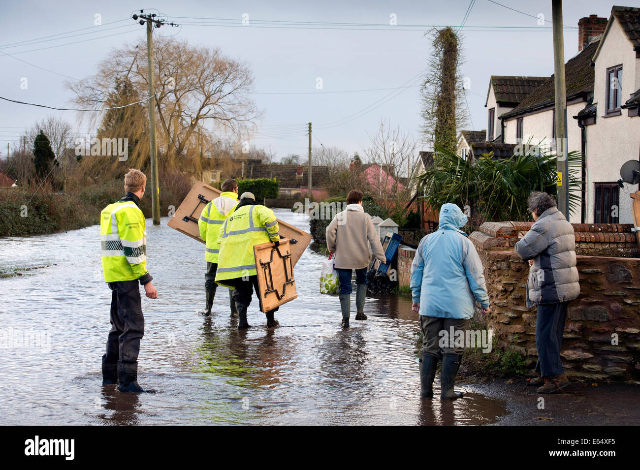 Residents carry posessions through floodwater in the village of