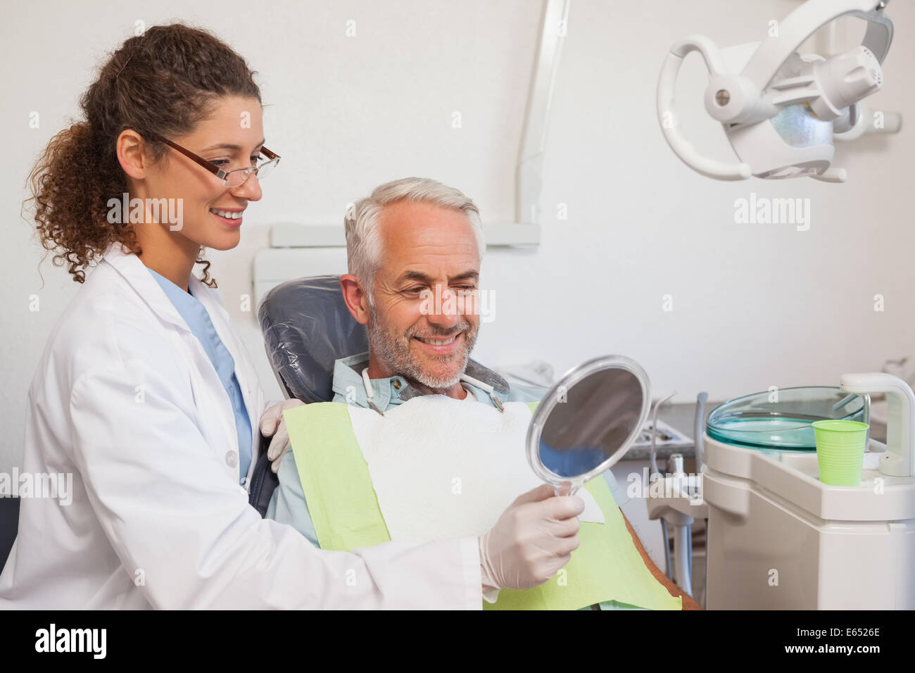 Dentist showing patient his new smile in the mirror Stock Photo - Alamy