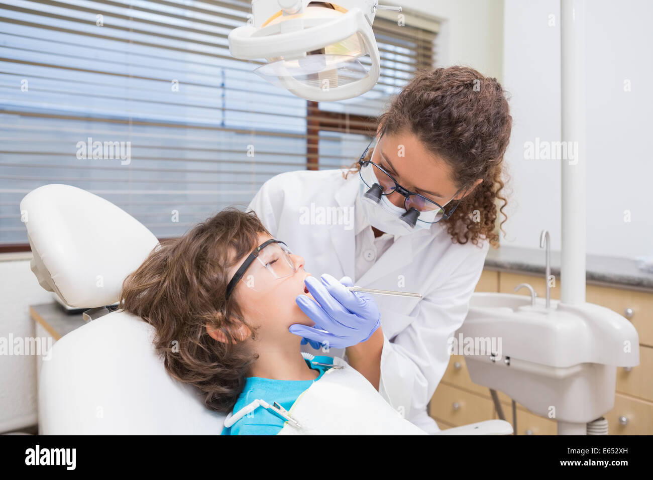 Dentista maschio in speciali occhiali con lenti di ingrandimento e  maschera. Operatore sanitario Foto stock - Alamy