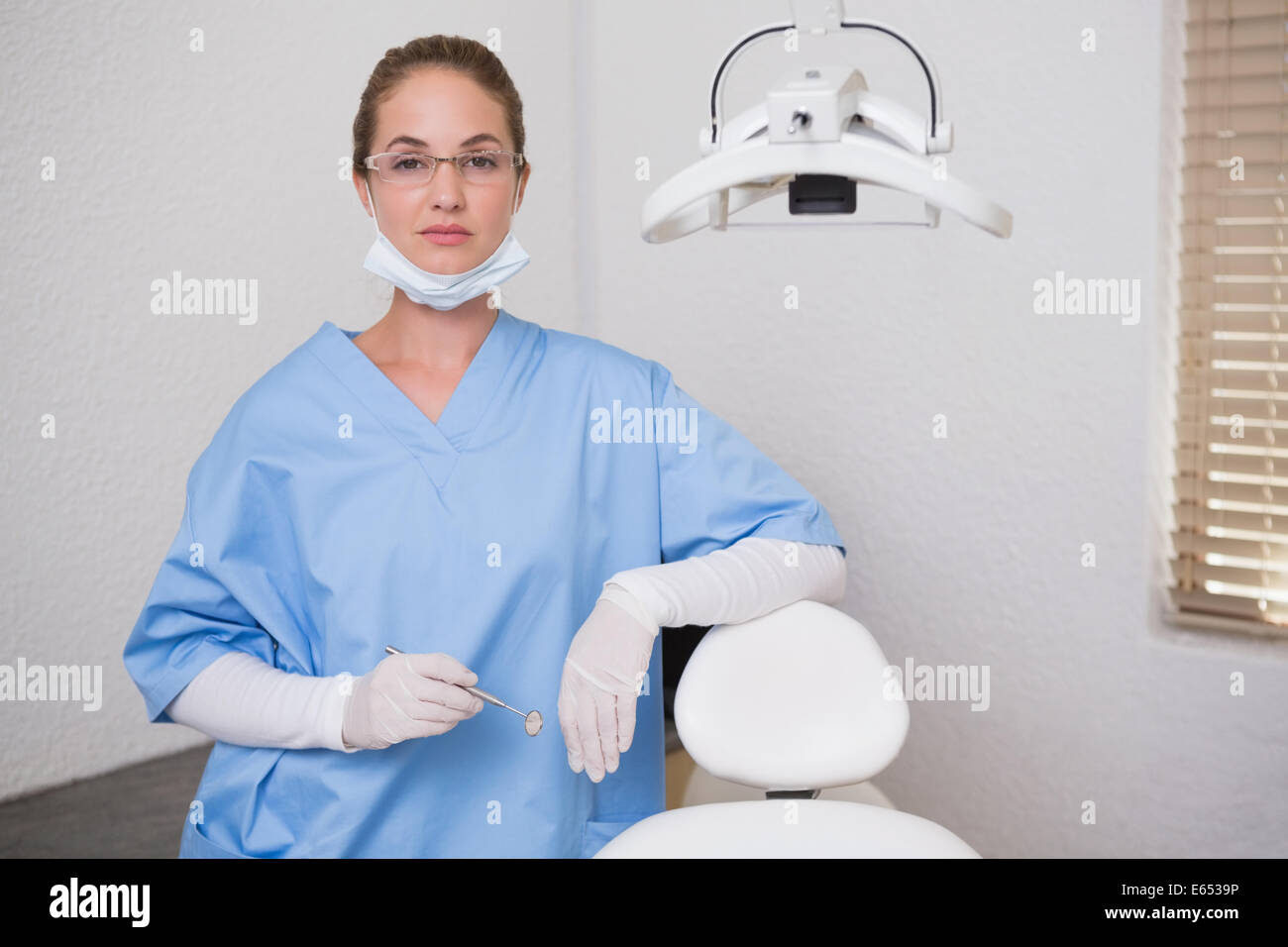 Dentist in blue scrubs looking at camera Stock Photo Alamy