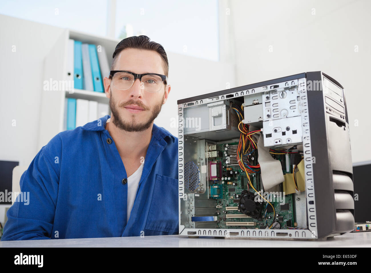 Computer engineer smiling at camera beside open console Stock Photo - Alamy