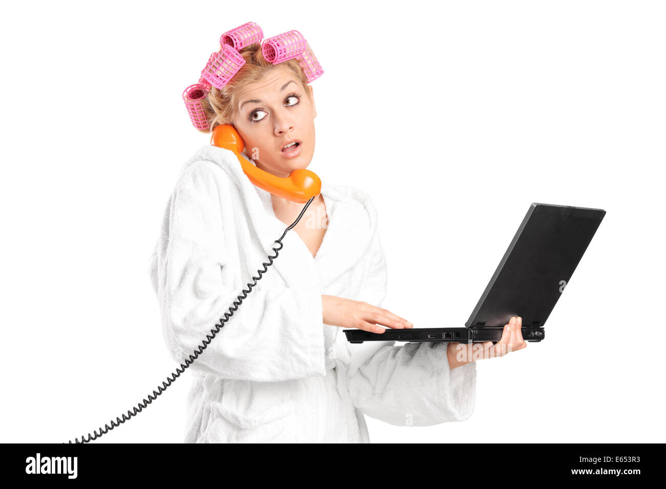 Surprised girl holding laptop and talking on phone isolated on white background Stock Photo