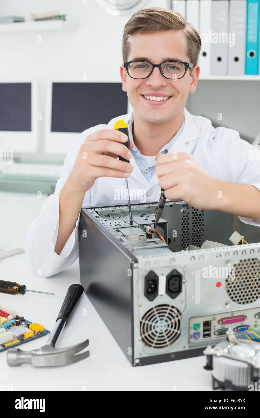 Computer engineer working on broken device with screwdriver Stock Photo