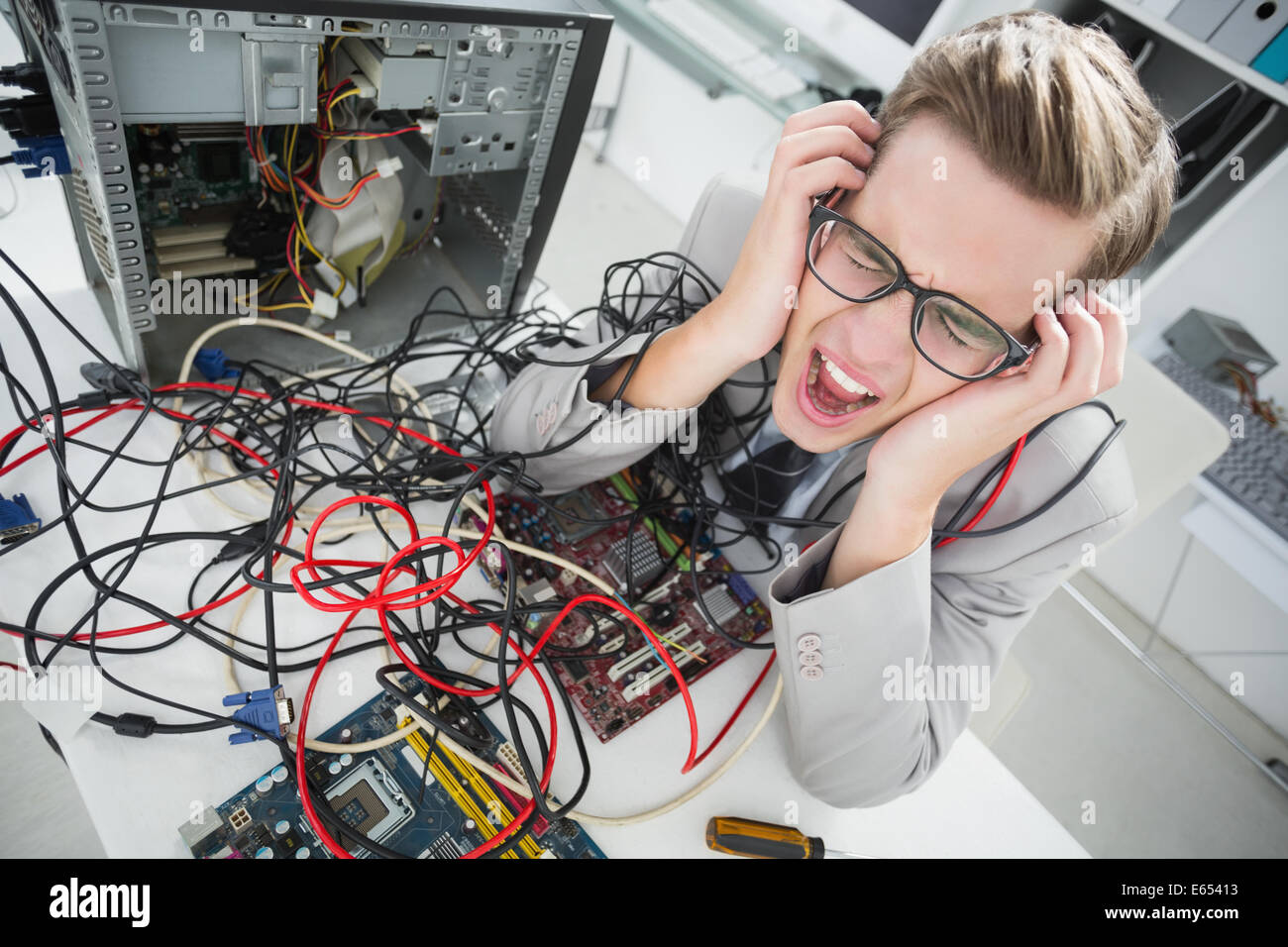 Stressed computer engineer working on broken cables Stock Photo - Alamy
