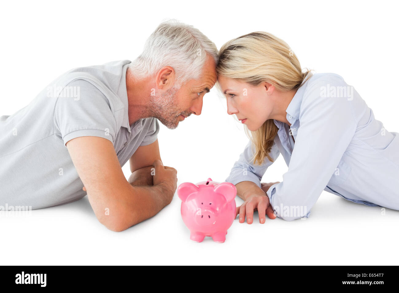 Happy couple lying with piggy bank Stock Photo - Alamy
