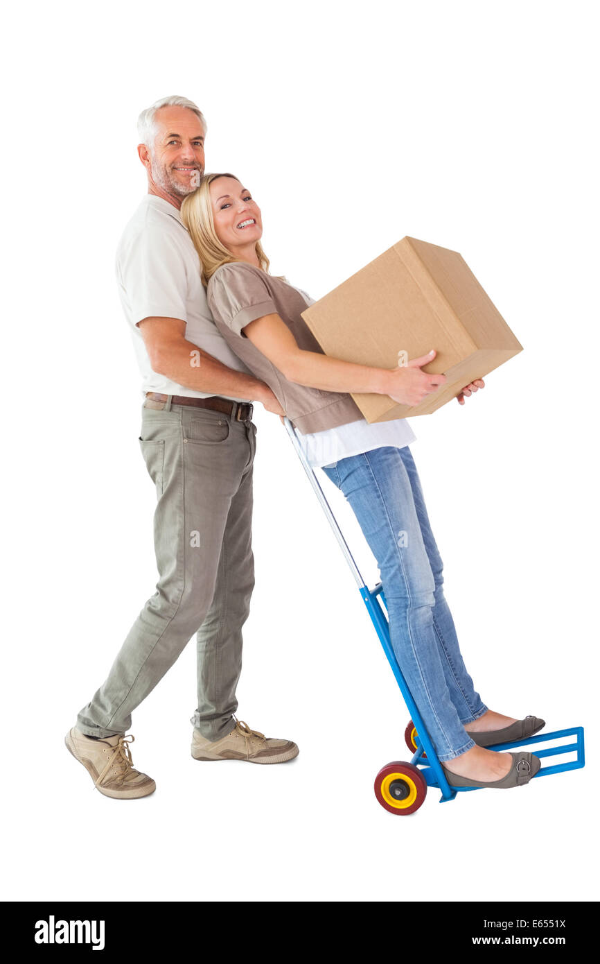 Happy couple having fun with trolley and moving box Stock Photo - Alamy