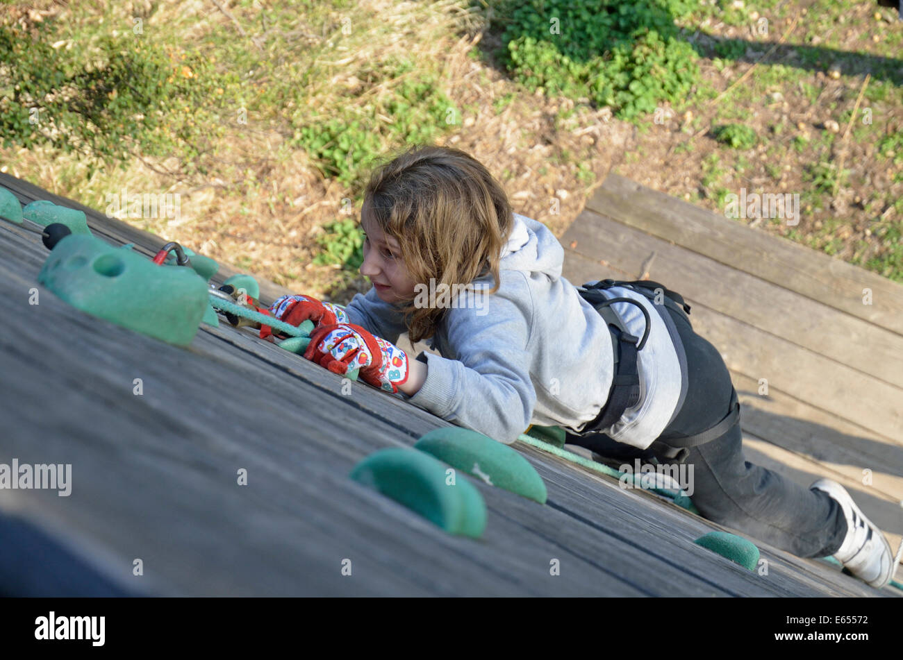 Girl (aged 10) climbing an outdoor climbing wall Stock Photo