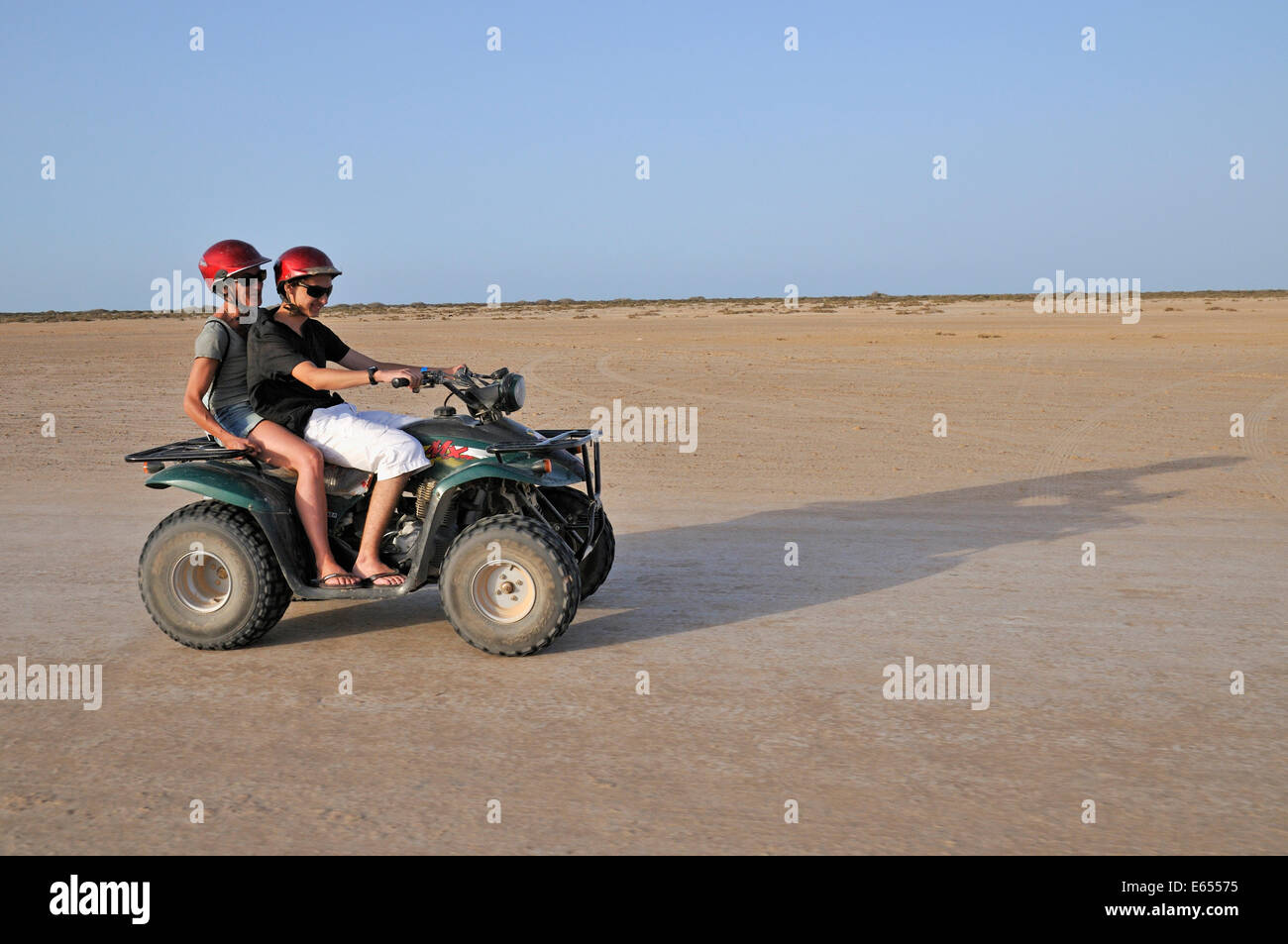 Teenage boy and his mother on an ATV quad bike in the desert, Tunisia, North Africa Stock Photo