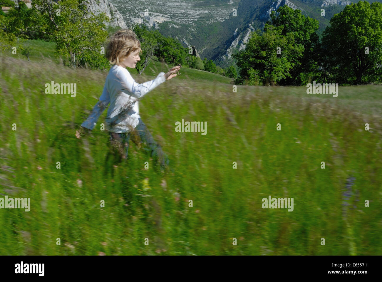 Little girl running through a meadow Stock Photo