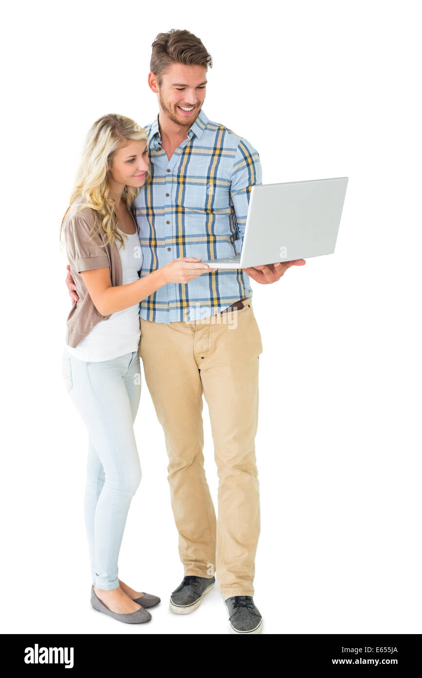 Attractive couple standing and using laptop Stock Photo - Alamy