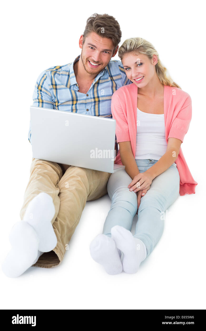 Attractive young couple sitting using laptop Stock Photo - Alamy