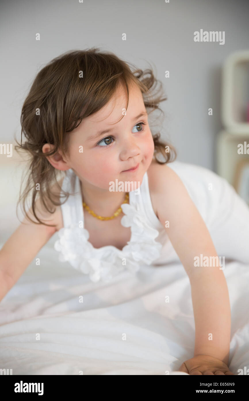 Close up of thoughtful girl looking away on bed Stock Photo