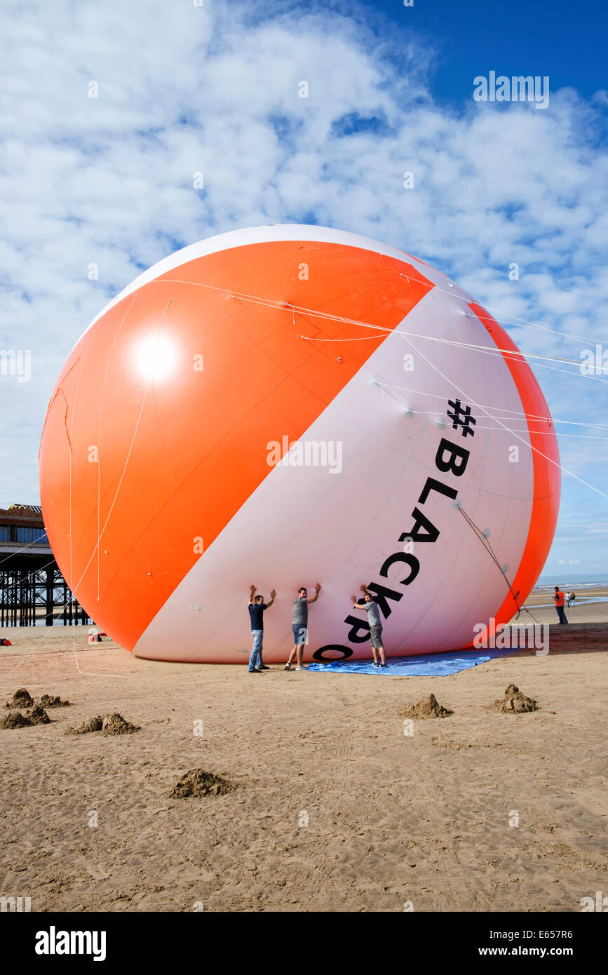 Blackpool now holds the Guiness World Record for the biggest beach ball in history. The seaside resort had it's achievement validated by Guiness World Records as it inflated the 18 meter diameter ball on the beach adjacent to Central Pier in Blackpool. The beach ball is three times the size of a typical house and is the same height as the White House in Washington DC, USA. Friday 15th August 2014 Stock Photo
