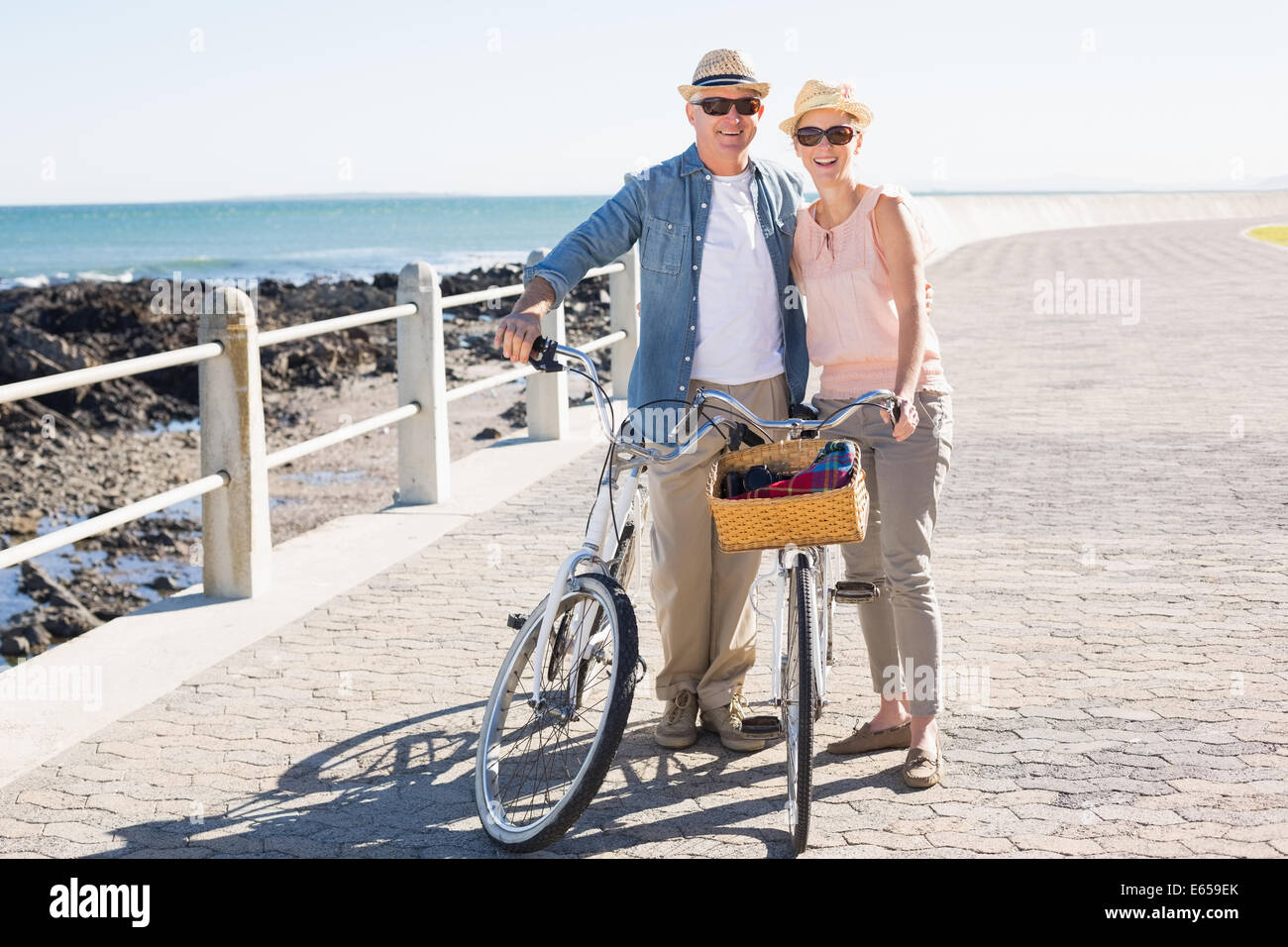 Happy casual couple going for a bike ride on the pier Stock Photo