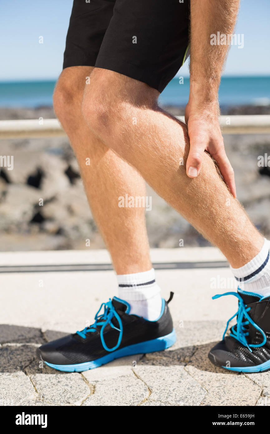 Fit man gripping his injured calf muscle Stock Photo
