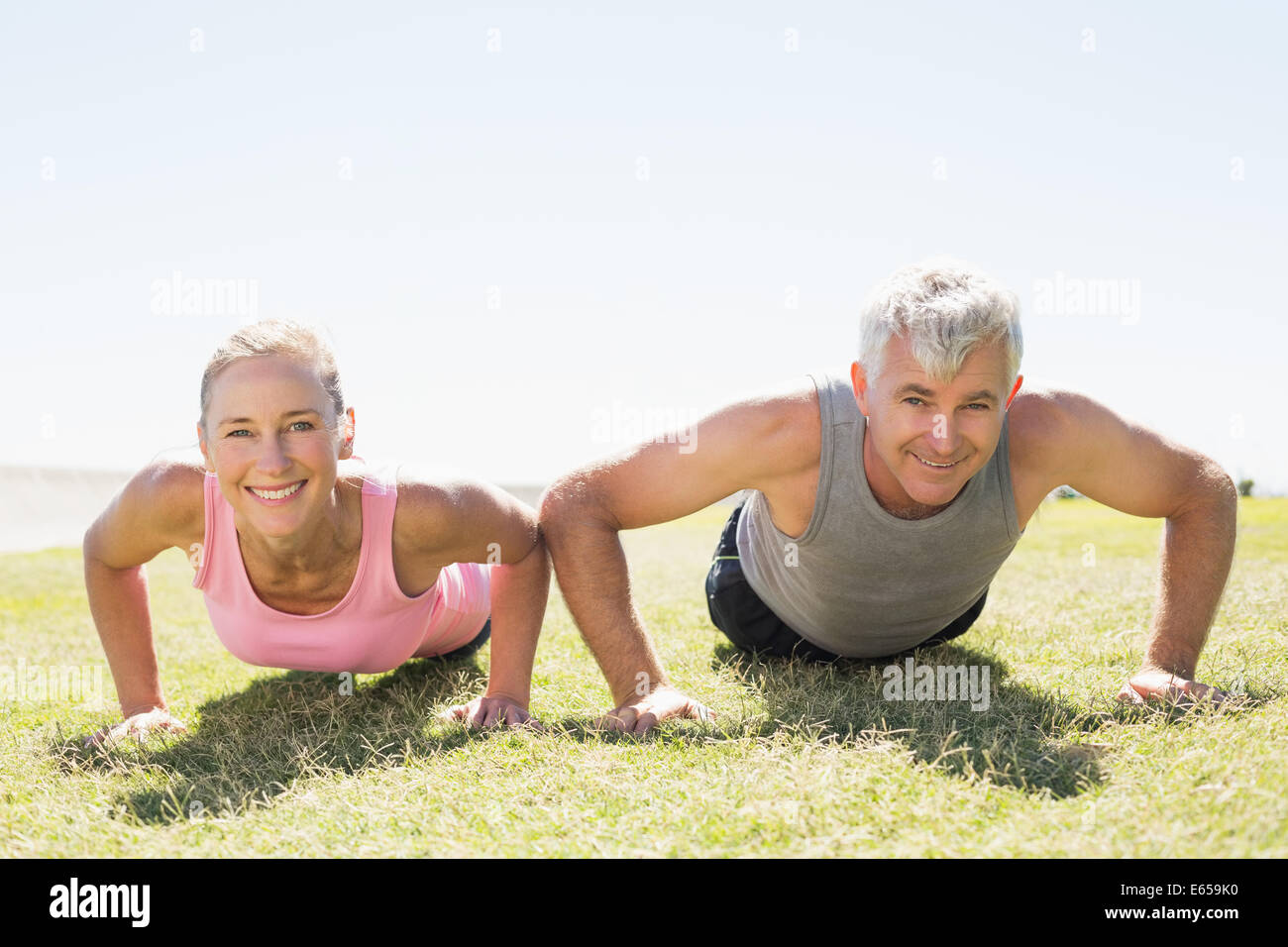 Fit mature couple warming up on the grass Stock Photo