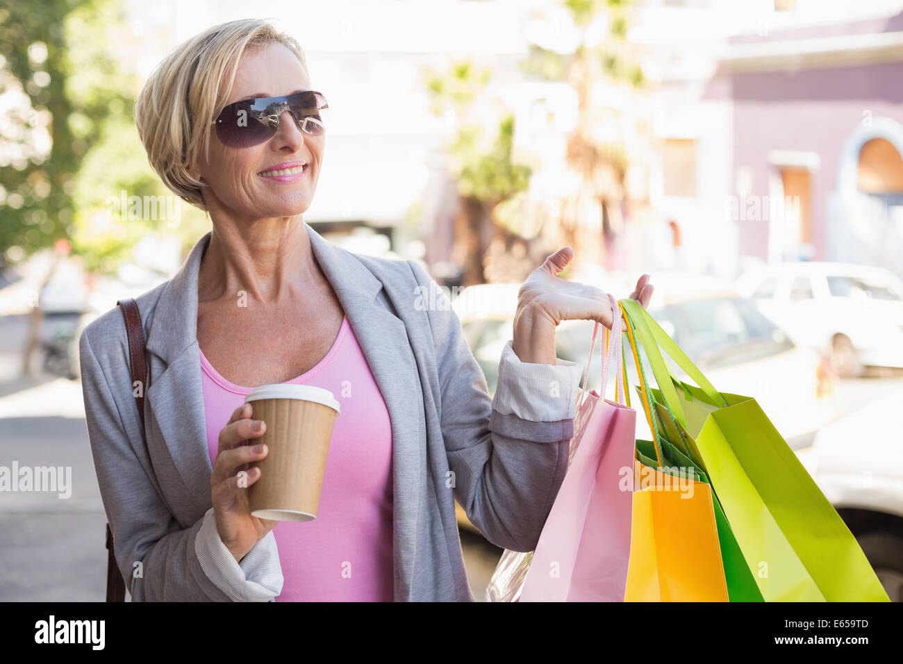 Happy mature woman walking with her shopping purchases Stock Photo