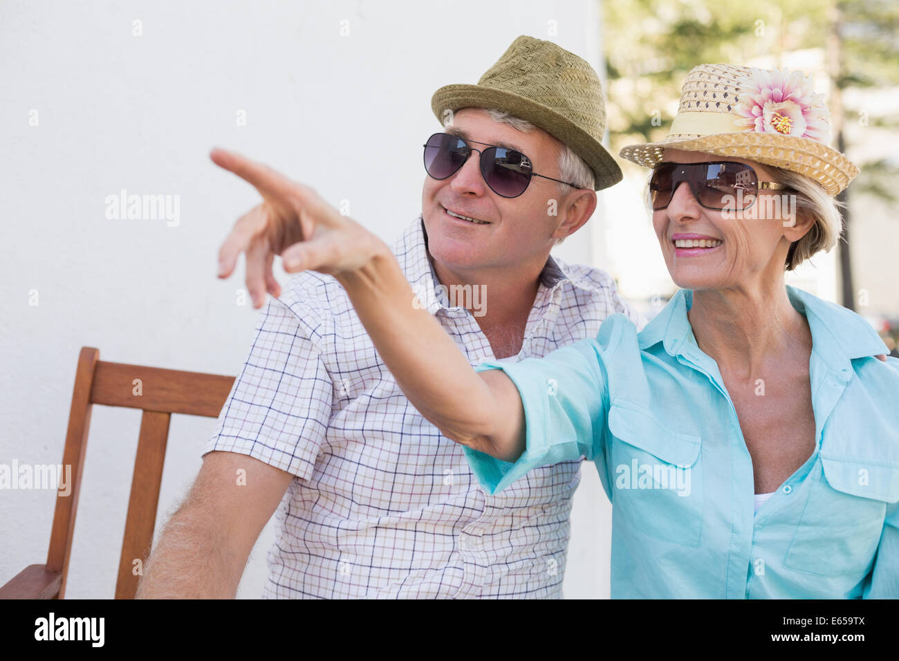 Happy mature couple sitting on bench in the city Stock Photo
