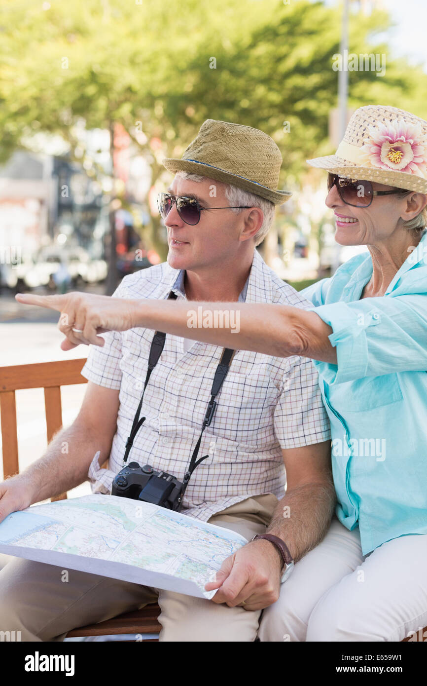 Happy tourist couple looking at map in the city Stock Photo