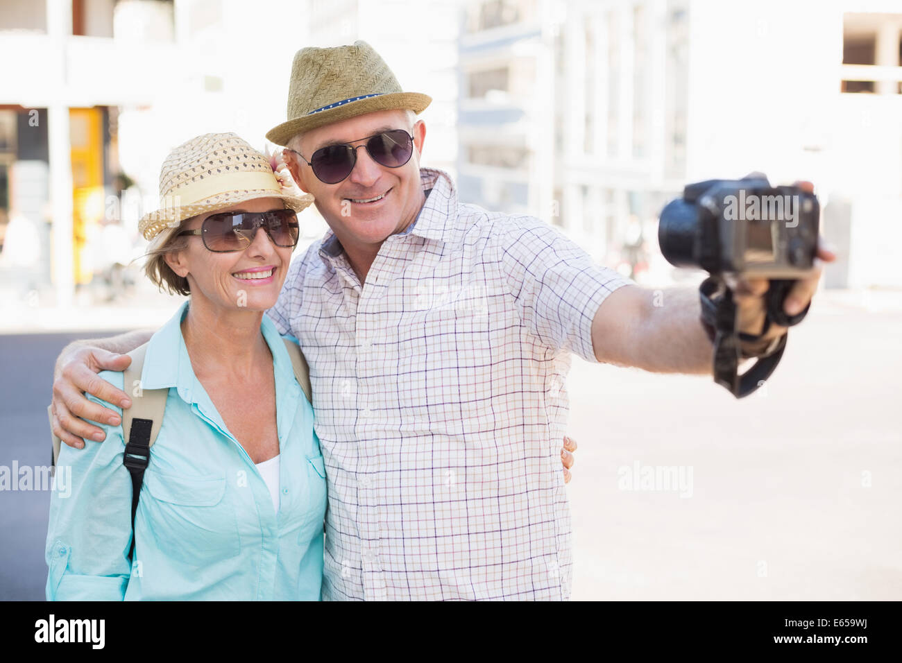 Happy tourist couple taking a selfie in the city Stock Photo