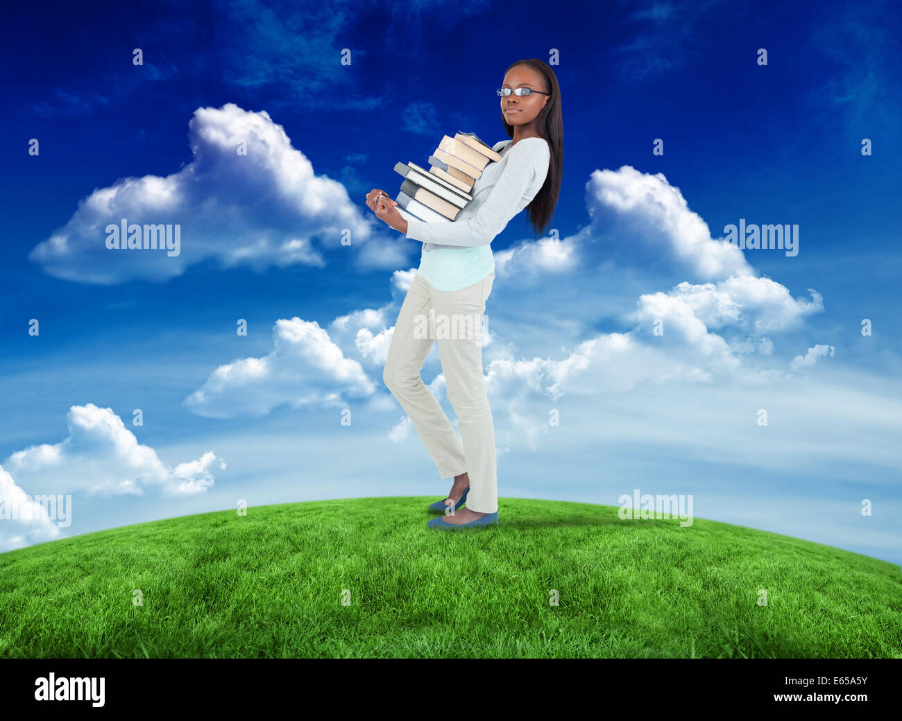 Composite image of side view of young woman carrying a pile of books ...
