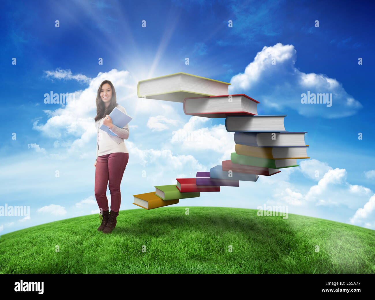Composite image of smiling student holding textbook Stock Photo