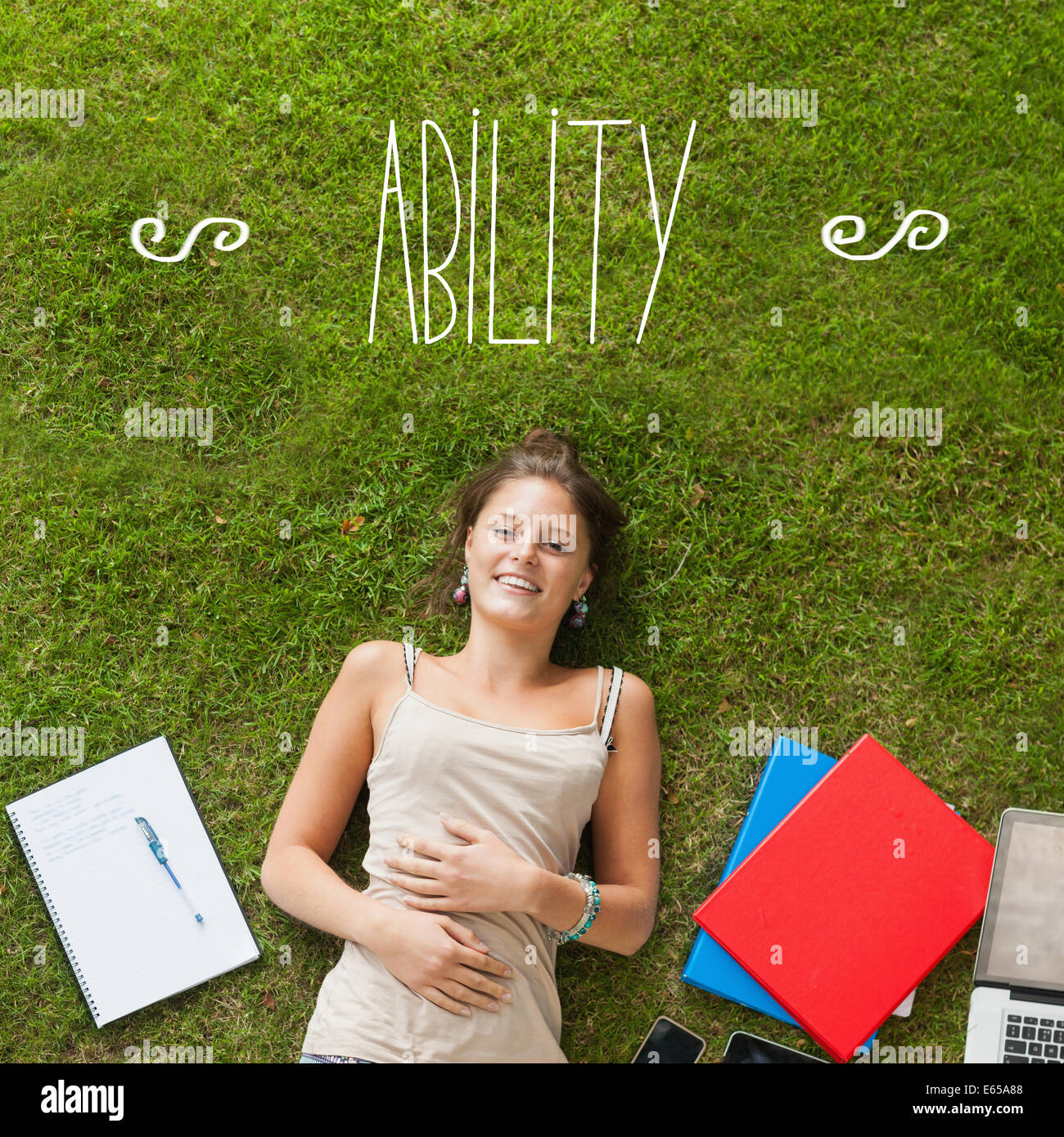 Ability against pretty student lying on grass Stock Photo