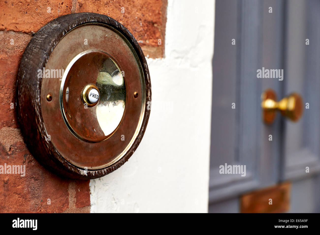 An old fashioned doorbell pictured next to a house front door. Stock Photo