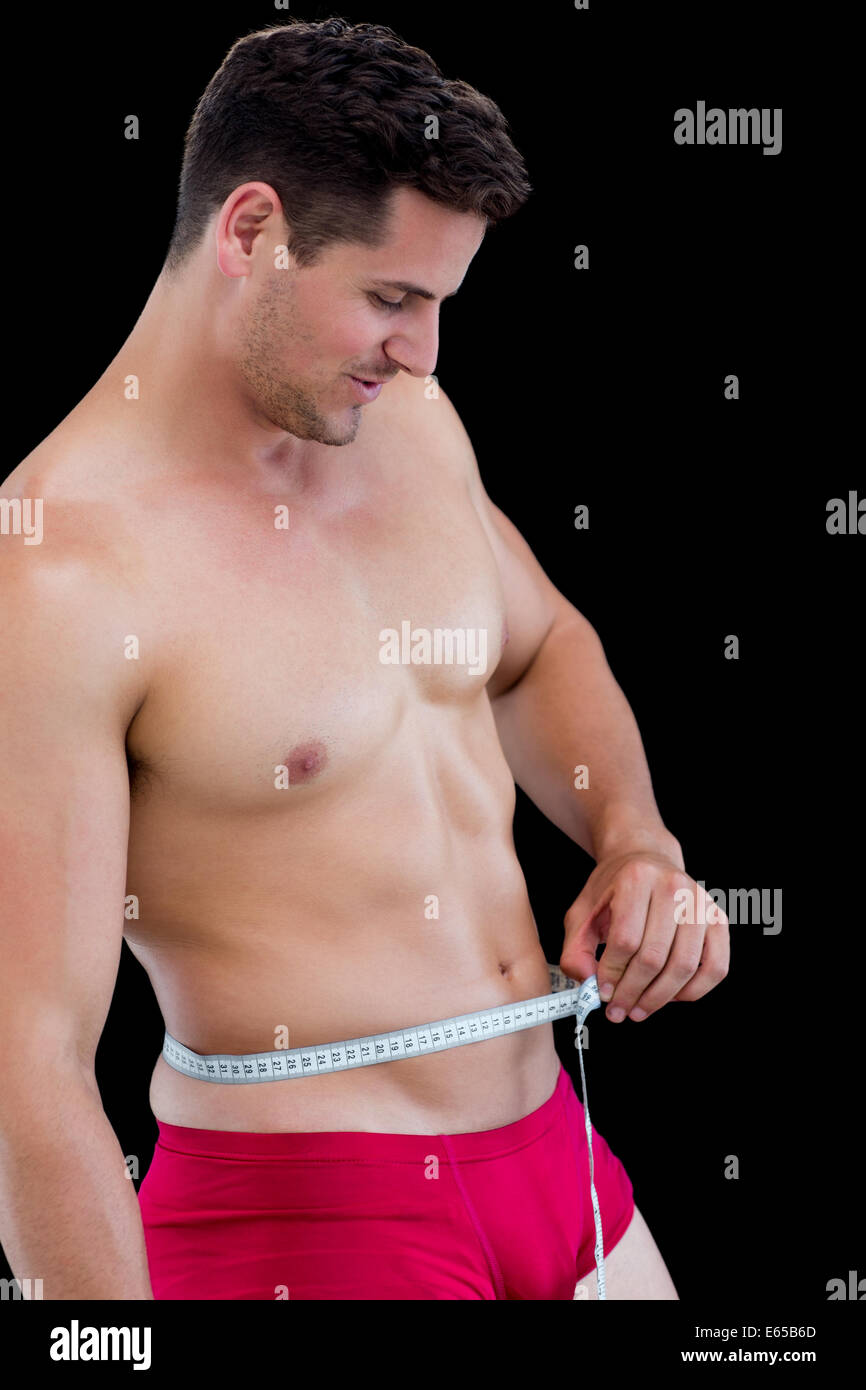 Side view of fit man measuring waist Stock Photo